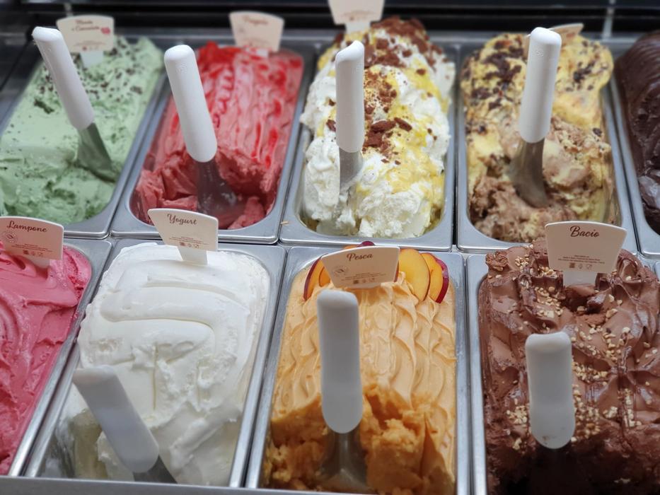 Multiple trays of ice cream in shop freezer