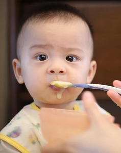Baby being fed baby food with spoon