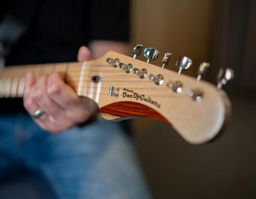 Närbild på en handformad gitarrhals och huvud