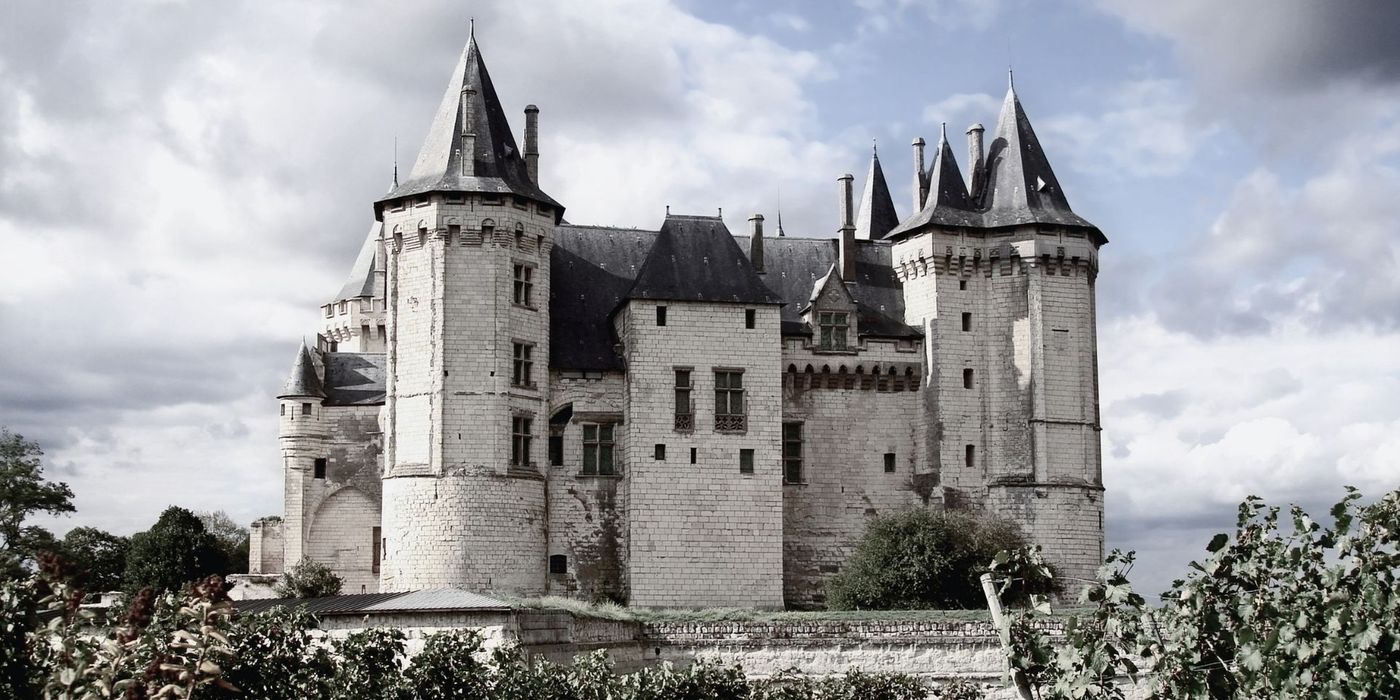 Historic French château with stone towers surrounded by green landscape