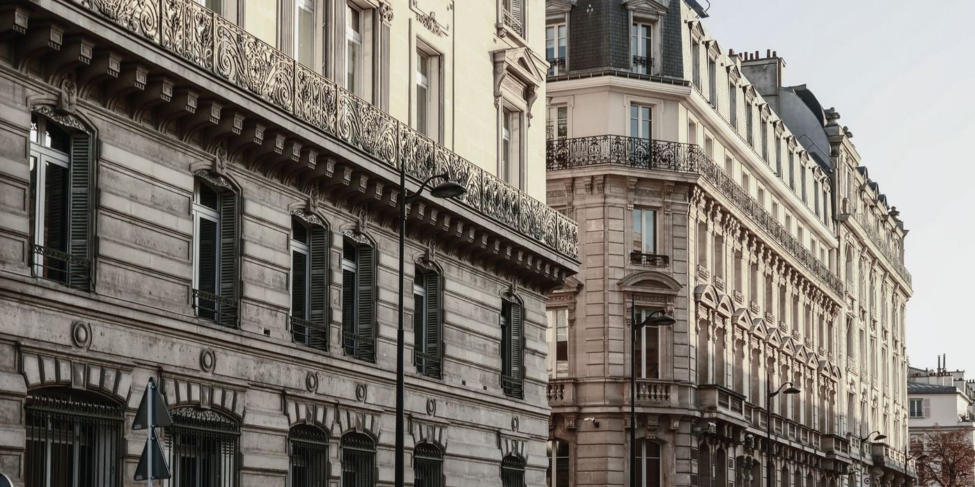 Classic Haussmann-style apartment building facade with wrought iron balconies in Paris