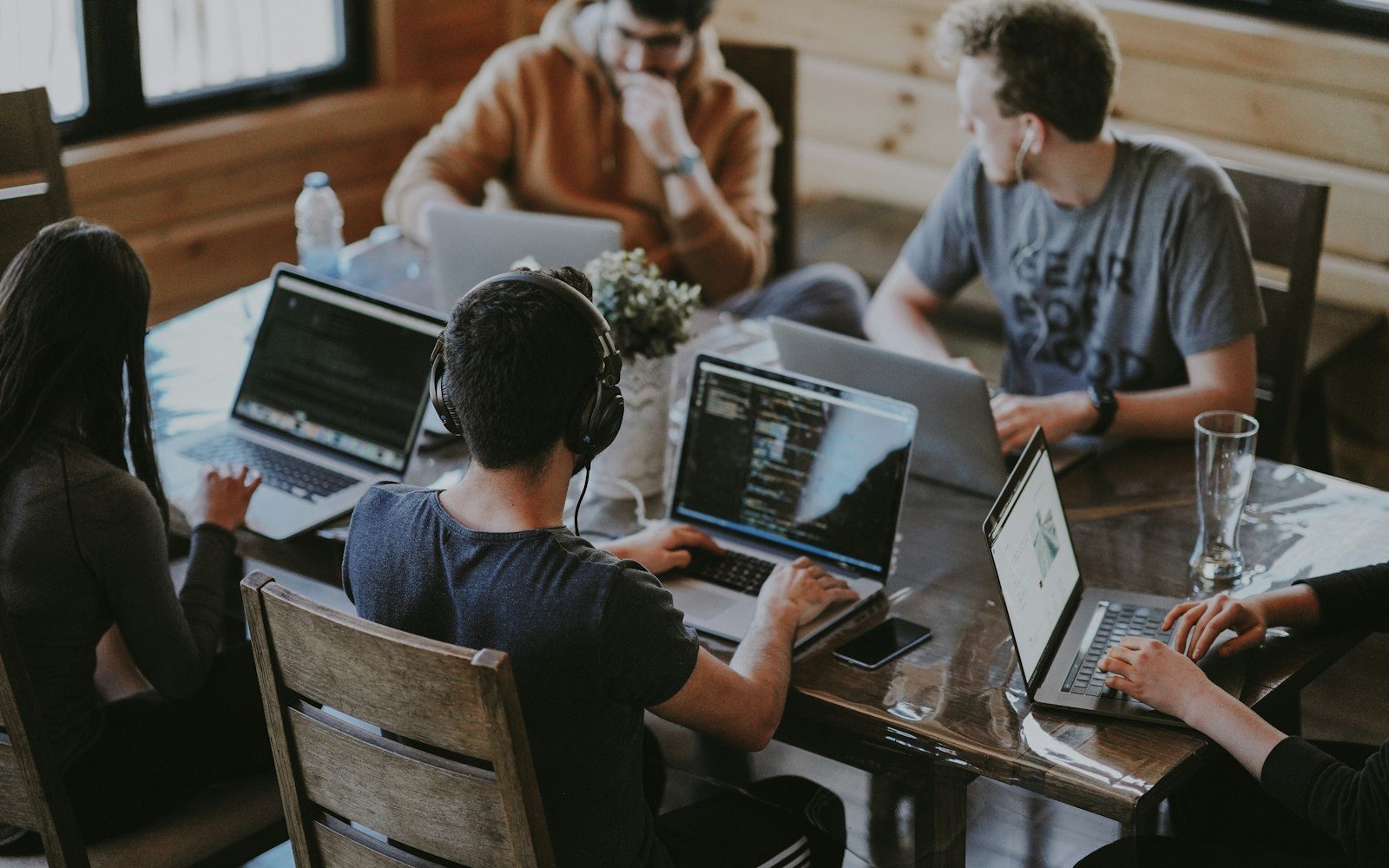 Imprenditore locale seduto a un tavolo mentre discute il progetto del sito con un professionista, laptop aperto e appunti