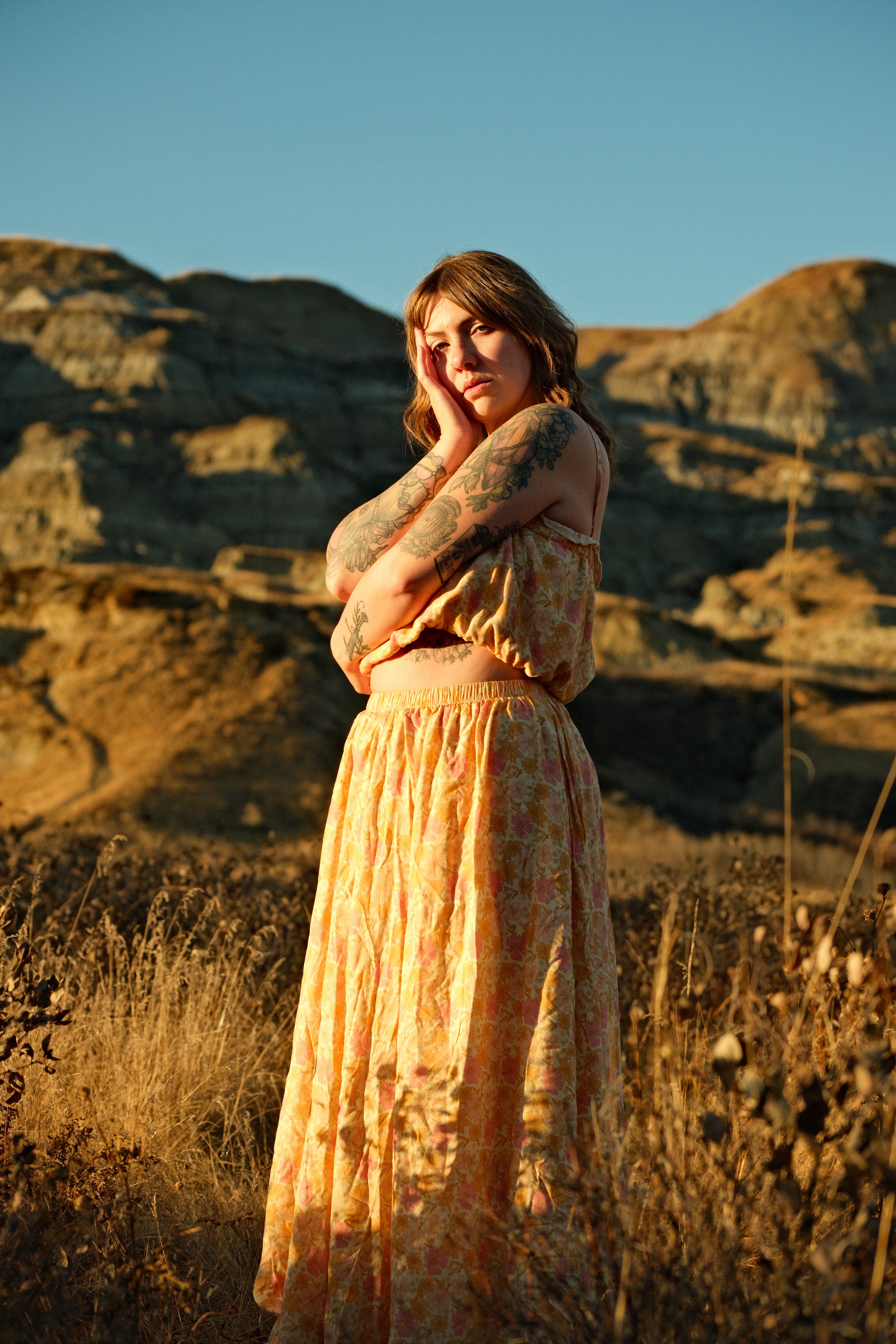 Rachel Peters wearing a flowing yellow dress in the sunlit badlands of Dry Island Buffalo Jump Provincial Park, Alberta.