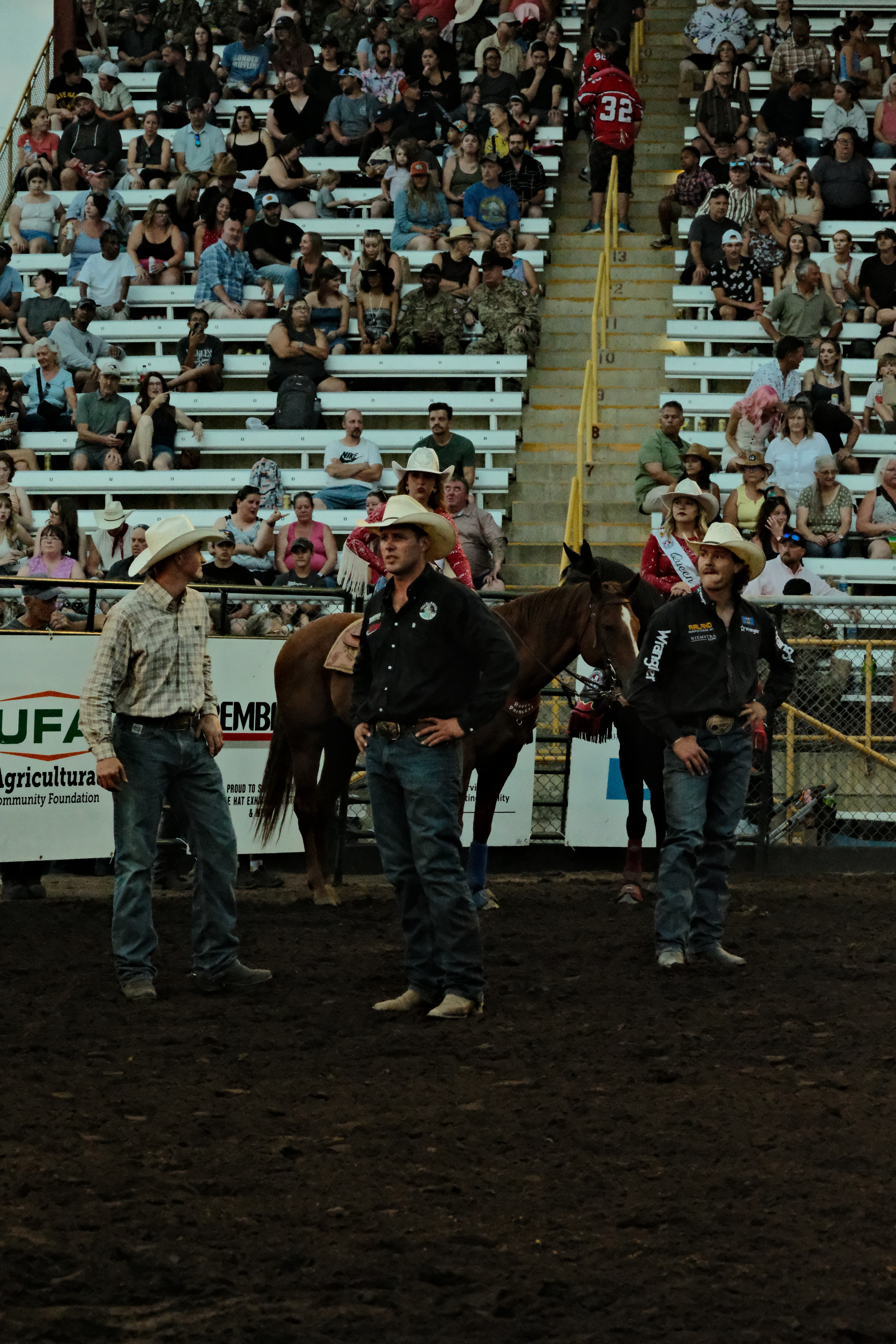 Rodeo riders and arena personnel gather around a horse following a roughstock ride in Medicine Hat, Alberta.