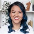 Jackie is wearing a white shirt with blue dyed hair.