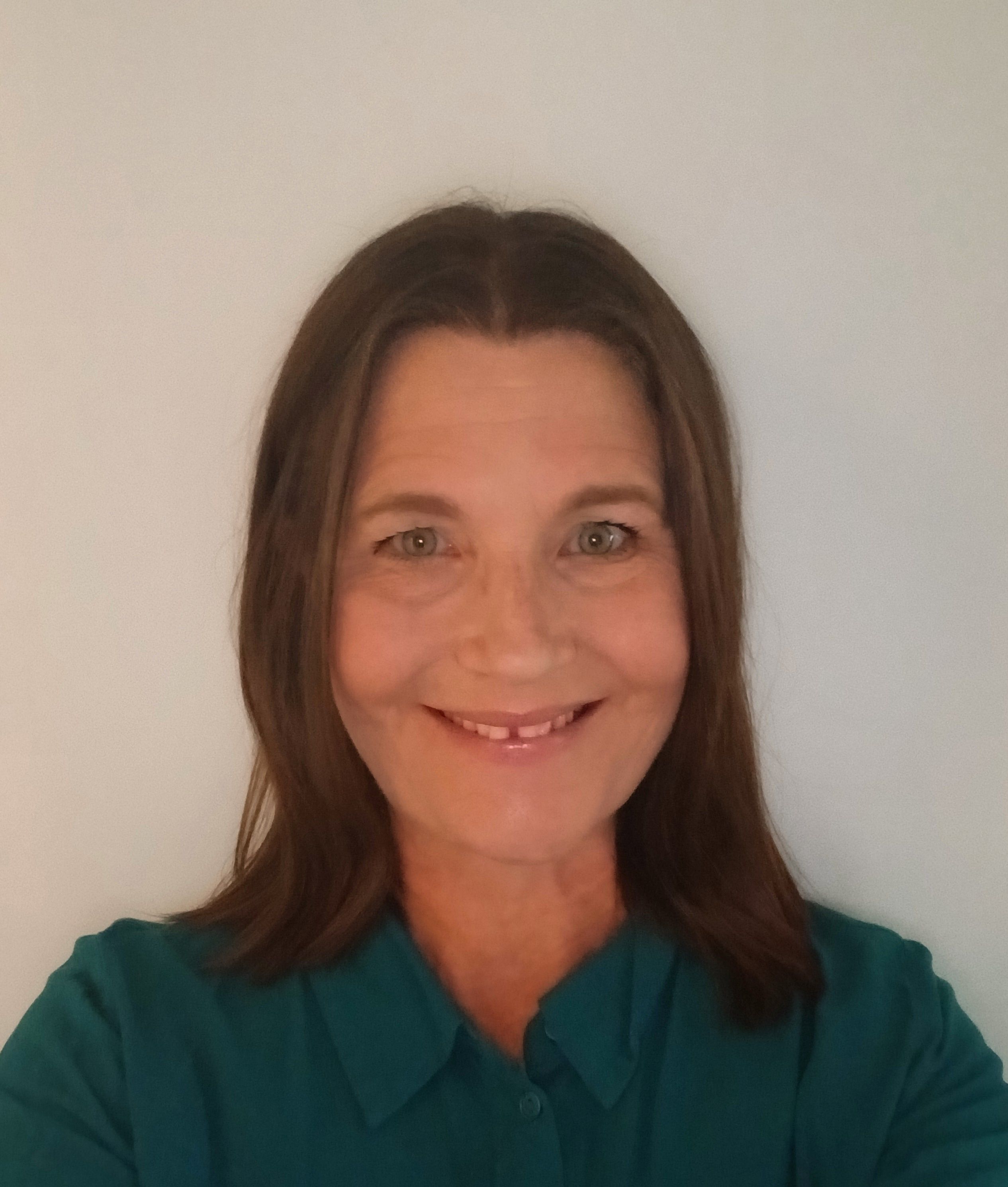 Woman on a white background wearing a green shirt.
