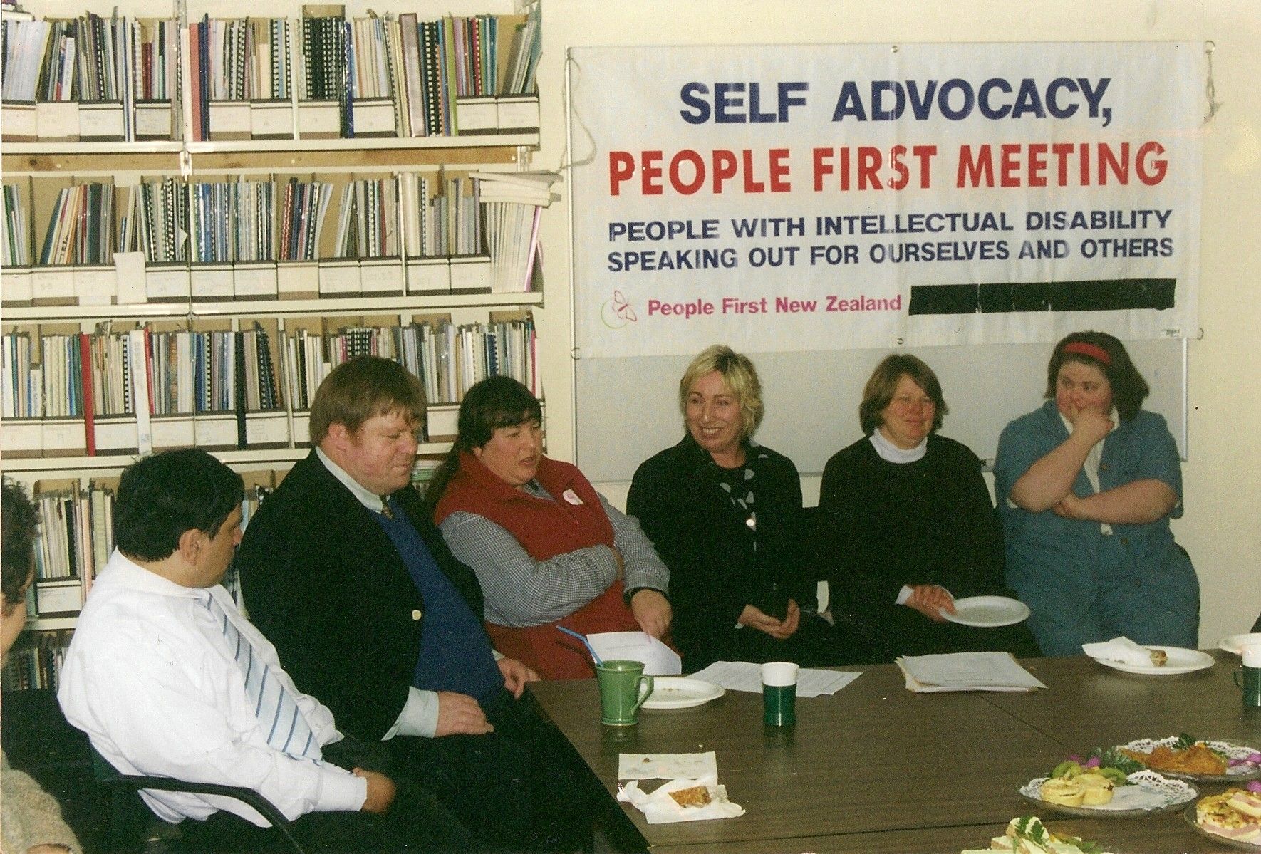 A group of people sitting at a People First Meeting