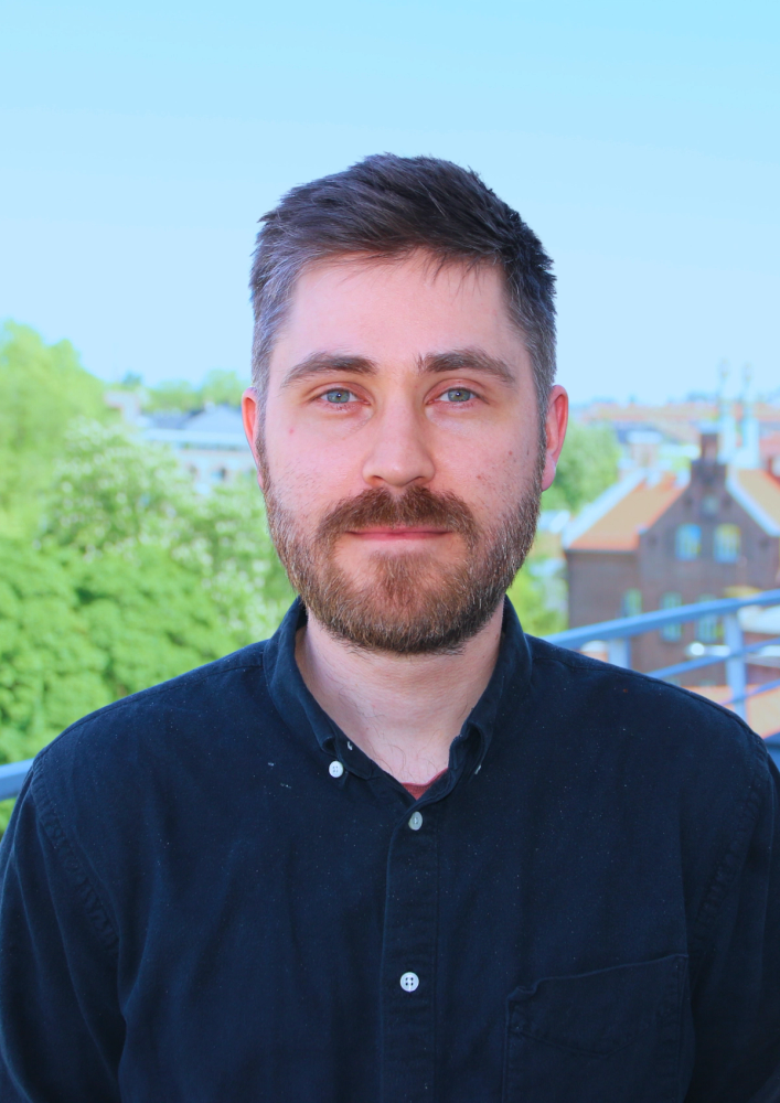 a man with a beard is wearing a black shirt