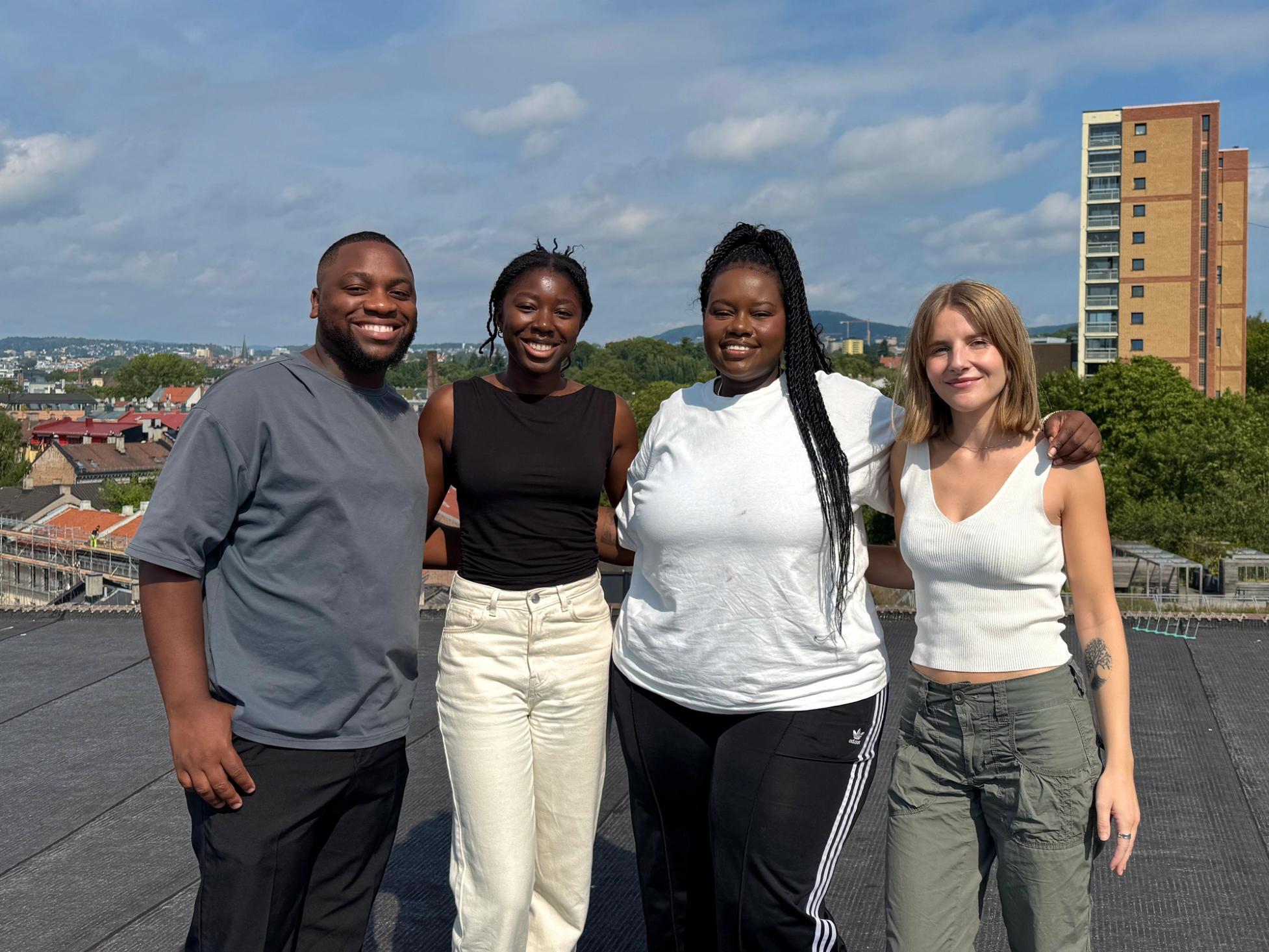a group of people are posing for a picture on a rooftop .