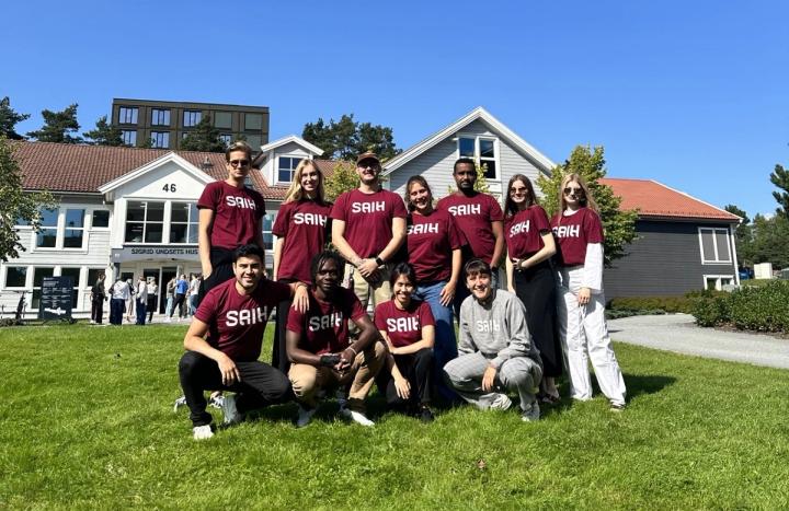 En gruppe studenter i SAIH-skjorter smiler og poserer sammen for et bilde.