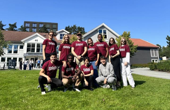 En gruppe studenter i SAIH-skjorter smiler og poserer sammen for et bilde.