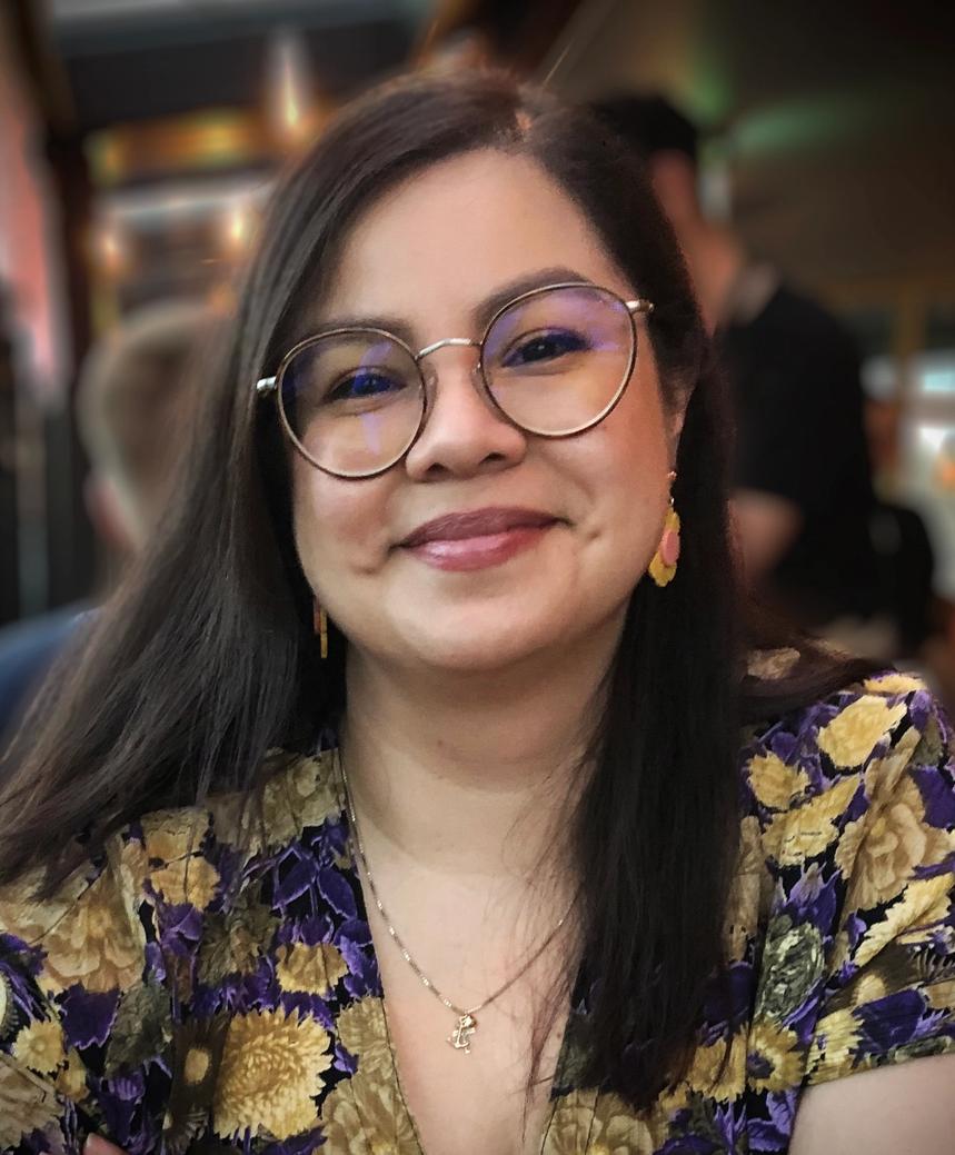 a woman wearing glasses and a floral shirt is smiling for the camera .