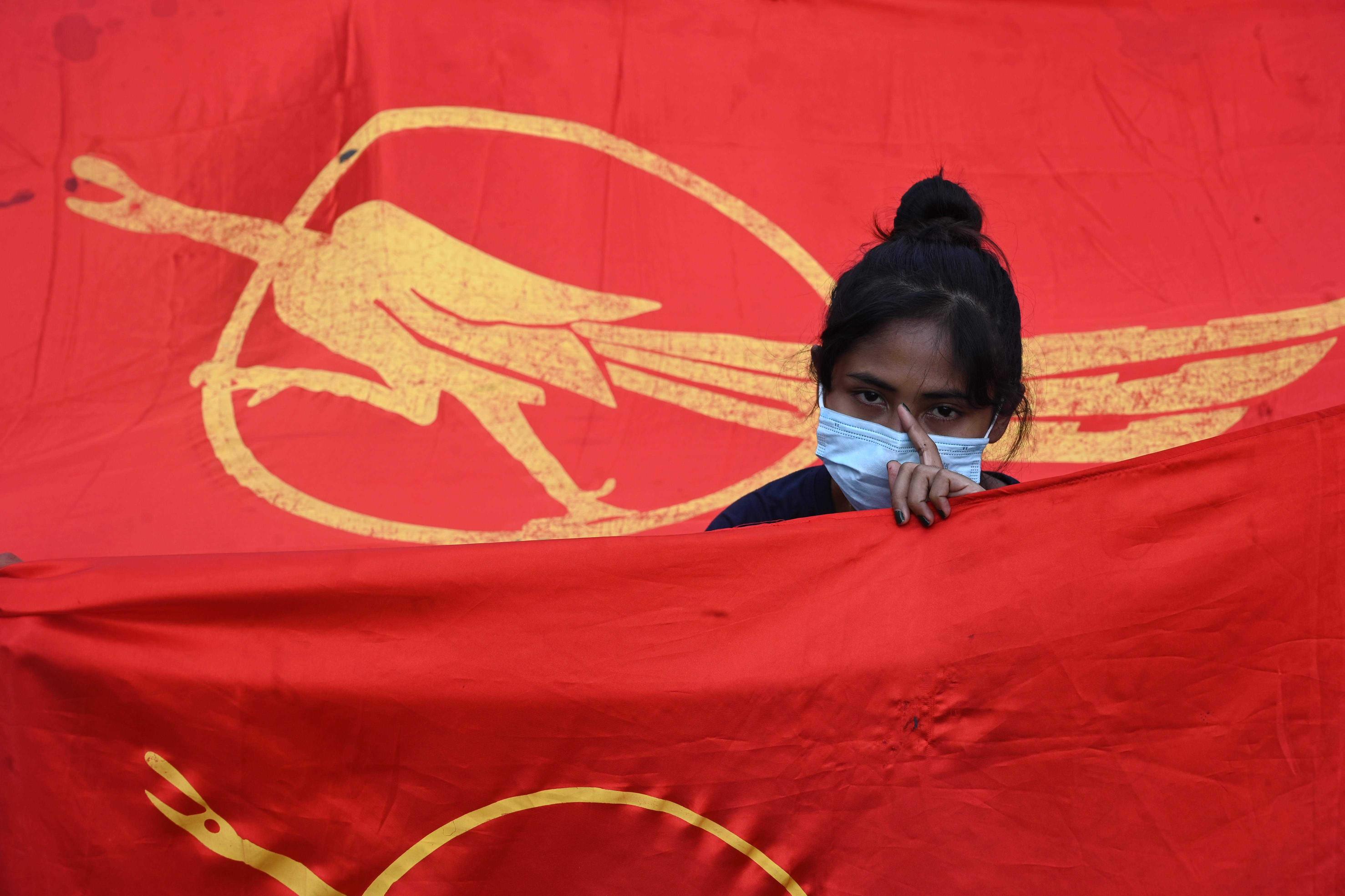 An activist stands with the flag of Myanmar's Student Movement during a demonstration against the military coup in Yangon on February 7, 2021. Photo: STR / AFP. 