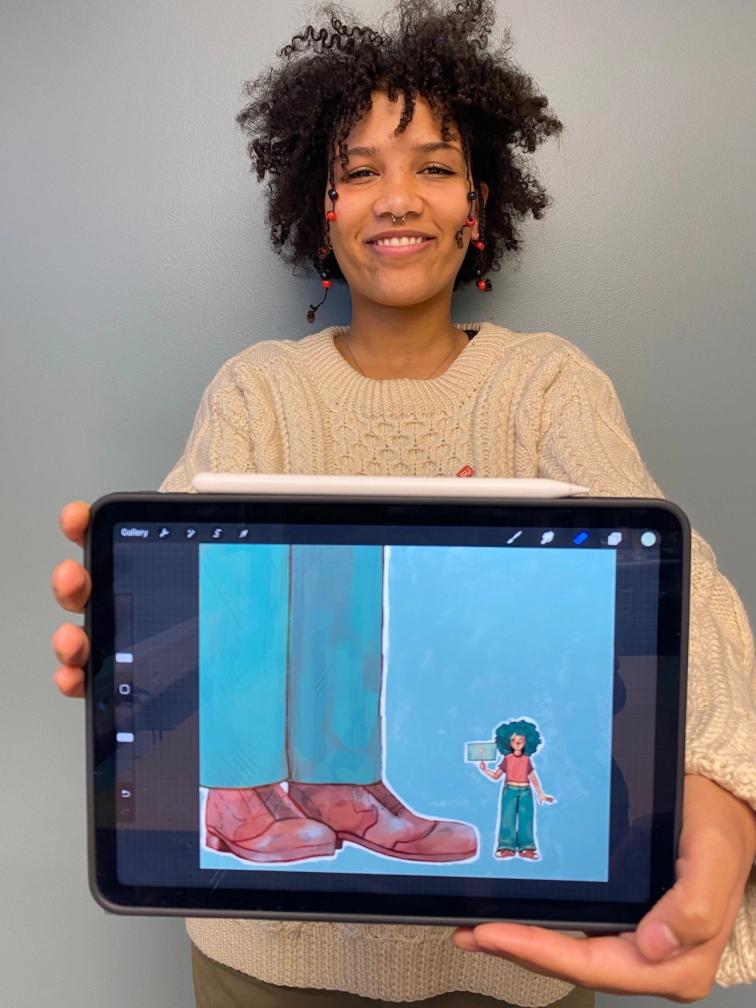 En ung kvinne holder frem en digital skjerm med et kunstverk på. 