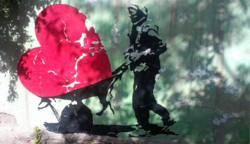 Stencil art of a soldier dragging a large, cracked red heart.