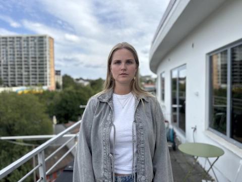 a woman is standing on a balcony looking at the camera .