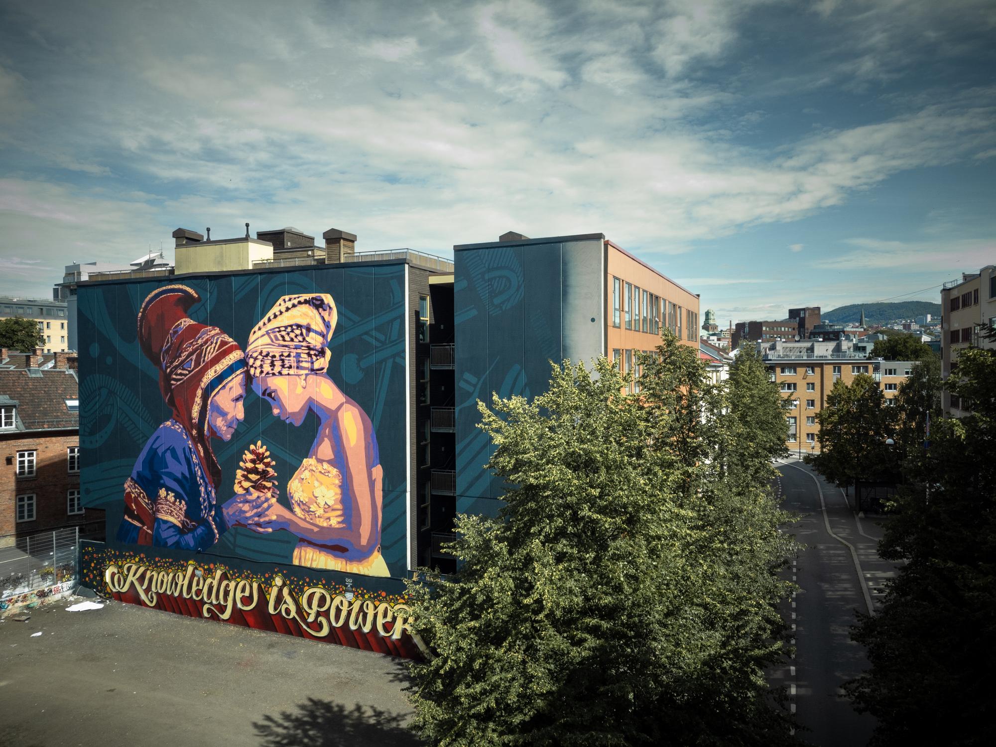 a large mural on the side of a building that says `` knowledge is power '' .