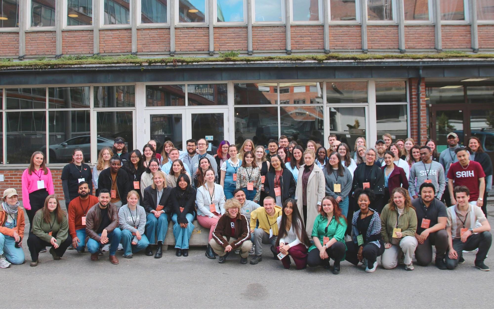 a large group of people are posing for a picture in front of a building .