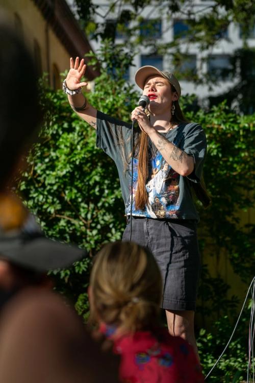 a woman is singing into a microphone in front of a crowd .