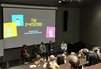 En panelsamtale foran et publikum med studenter.