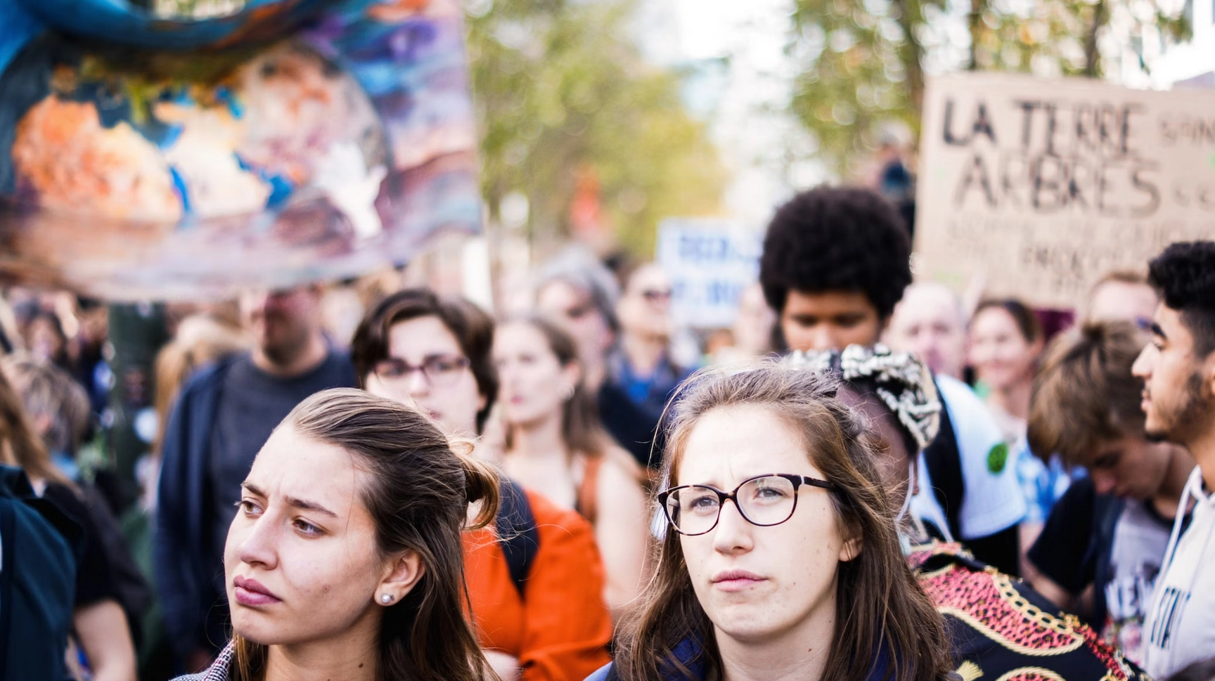 Students march down the street, waving flags