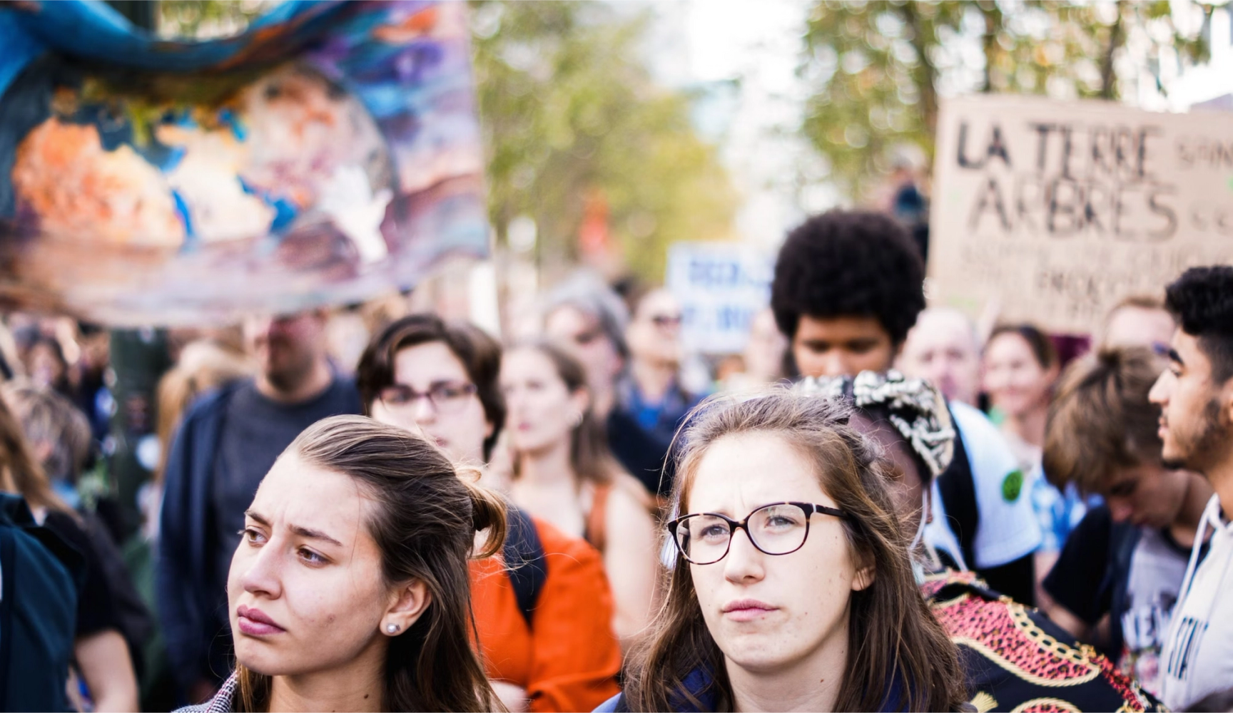 a group of people gathered in front of a sign that says la terre
