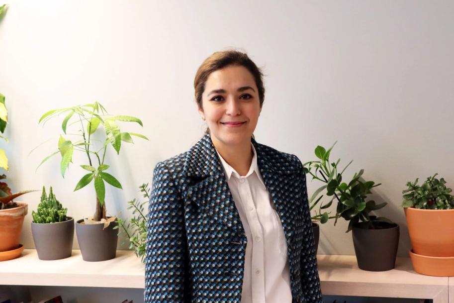 a woman is standing in front of a shelf filled with potted plants .