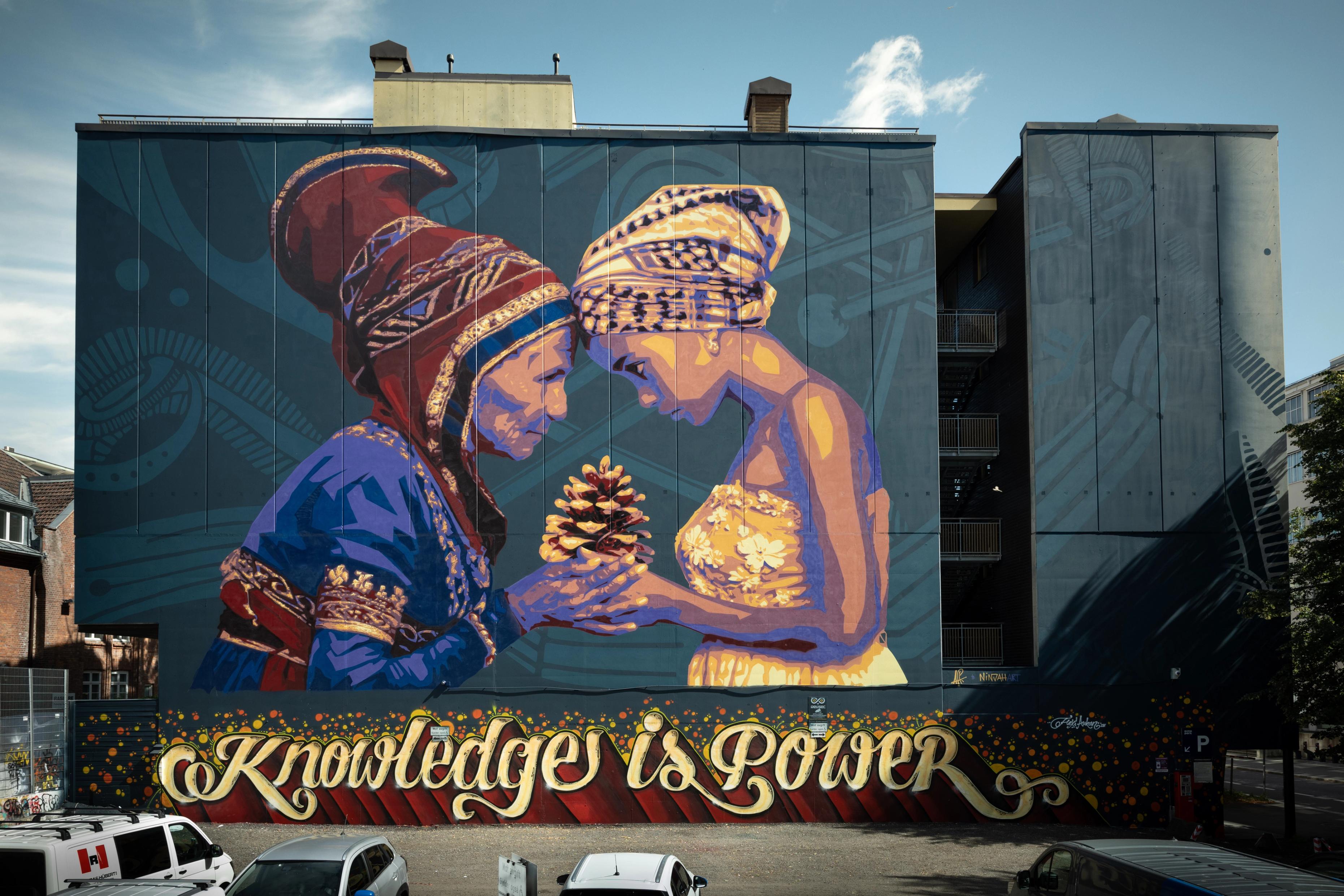 a large mural on the side of a building that says `` knowledge is power '' .