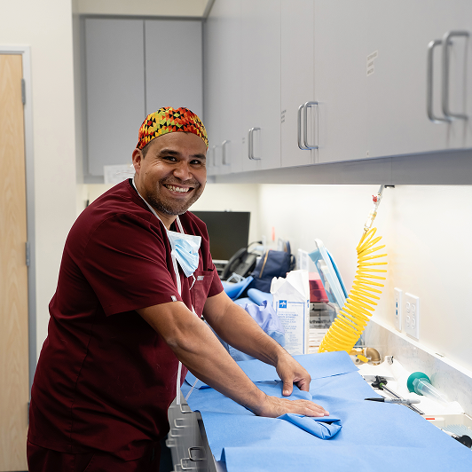 Veterinary professional in a clinical setting with medical equipment around.