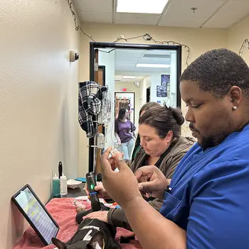 Veterinary professionals caring for a dog in a clinical setting with medical equipment around them.