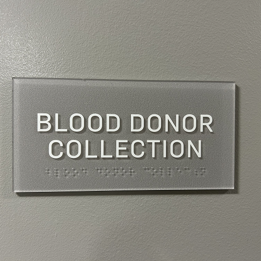 Gray sign with bold white type saying "blood donor collection".