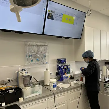 Veterinary professional in a clinical setting with medical equipment around.