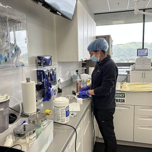 Veterinary professional in a clinical setting with medical equipment around.