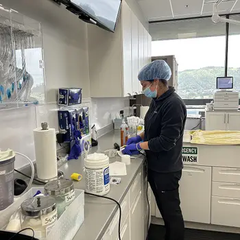 Veterinary professional in a clinical setting with medical equipment around.