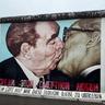 a mural of two men kissing on a wall