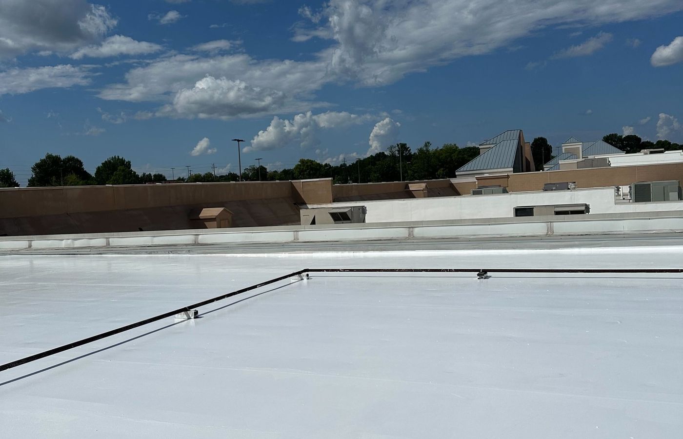Large retail roof section restored with a white silicone coating in Newnan
