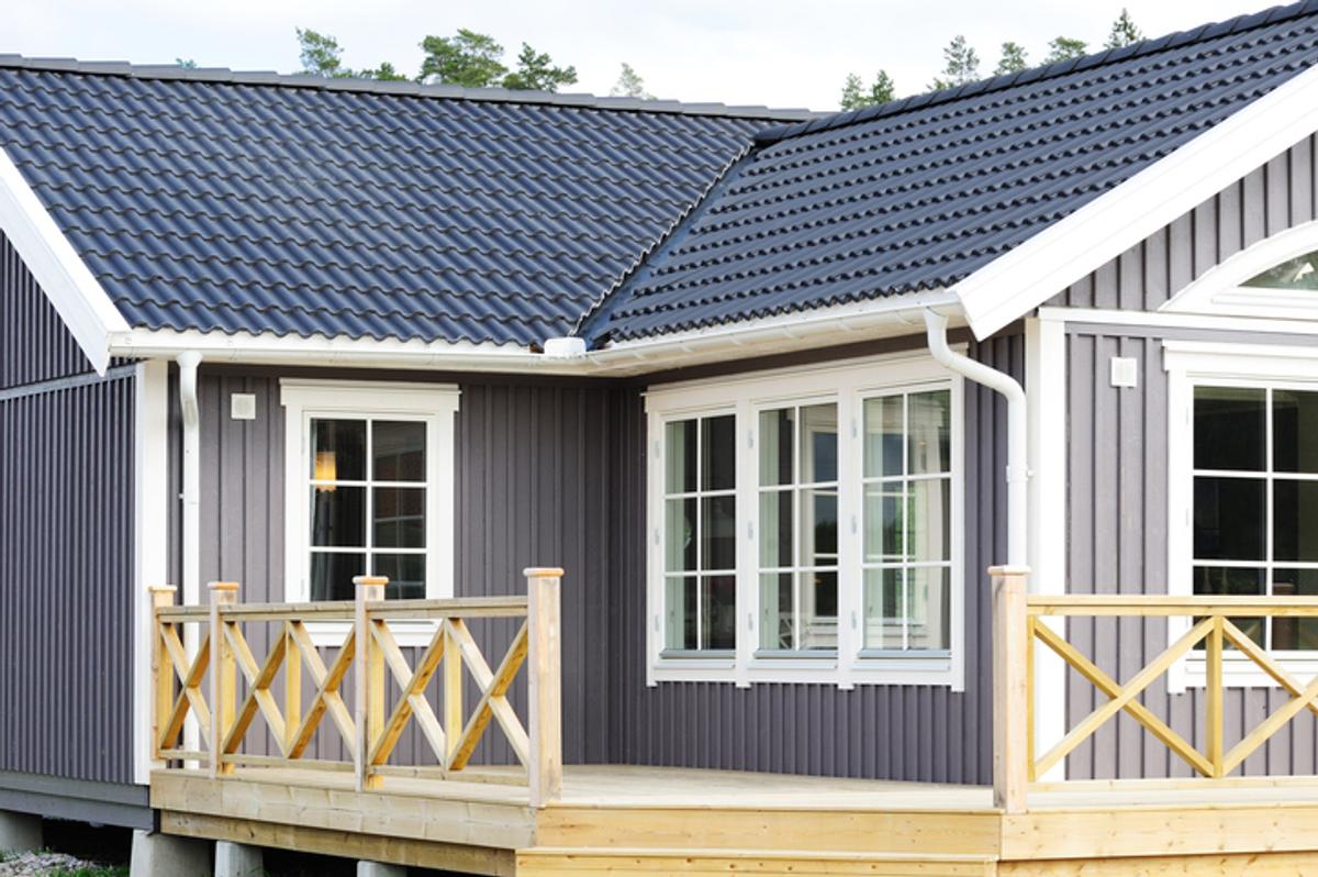 Nybygget gråblått hus med terrasse.