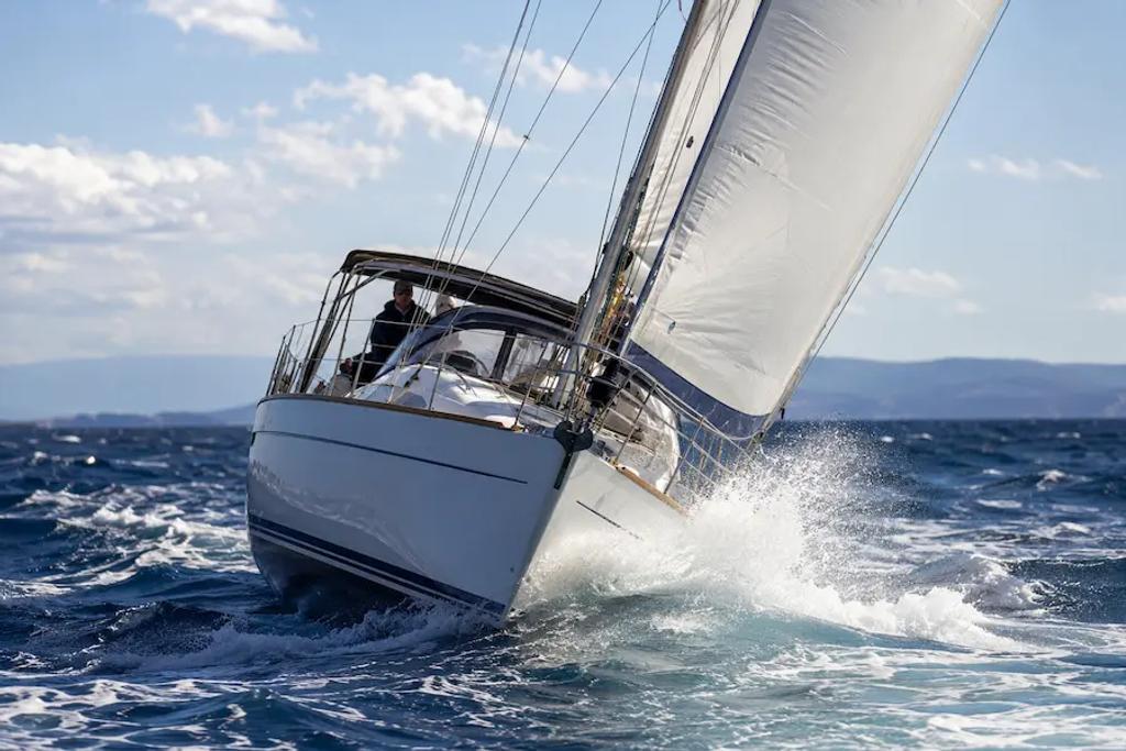 Monohull sailboat heeling under sail in moderate wind conditions