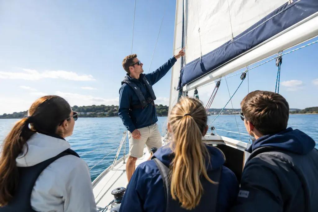 Students learning to sail during a sailing school lesson on the water