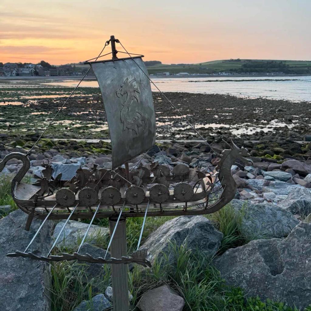 A Viking longship sculpture on a Scottish shore