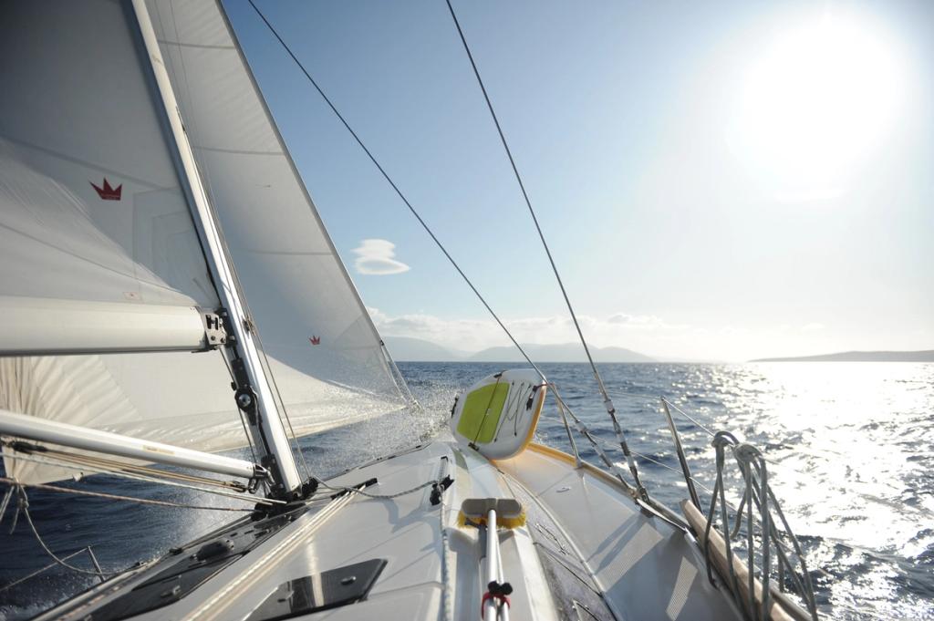 A sailboat going at high speed, the wind blowing water over the bow.