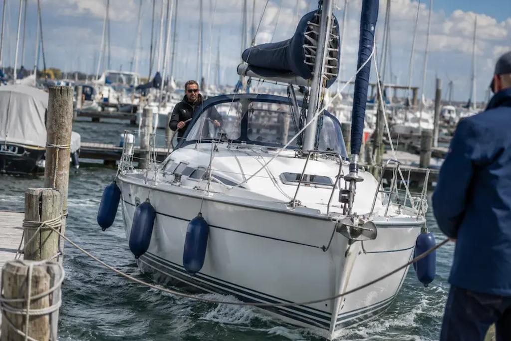 Skipper docking a sailboat in a marina, a skill not covered in basic sailing school