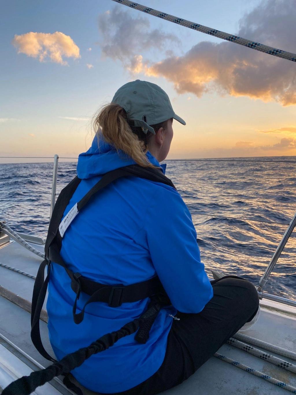 Elouise sitting on the rail at sunset, offshore