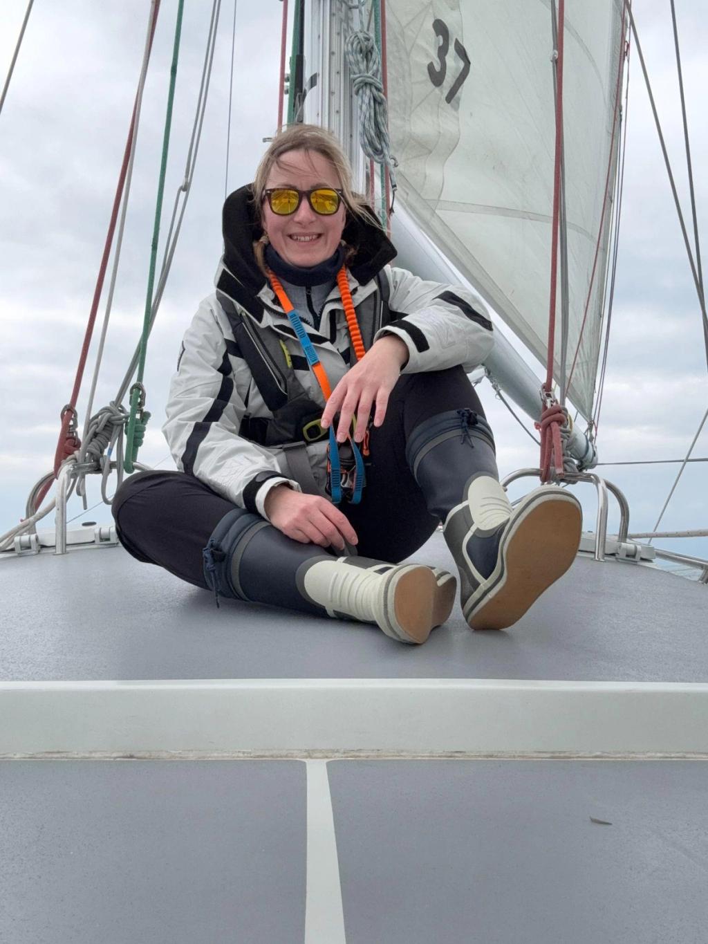 Elouise sitting on the foredeck of a yacht under sail