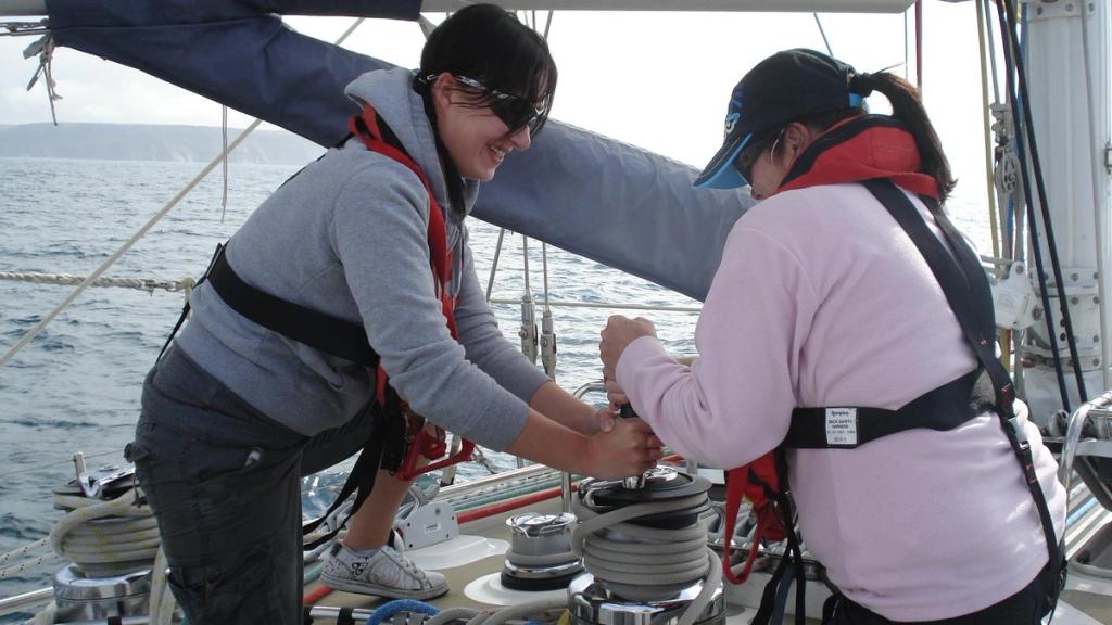 Two crew working a winch offshore