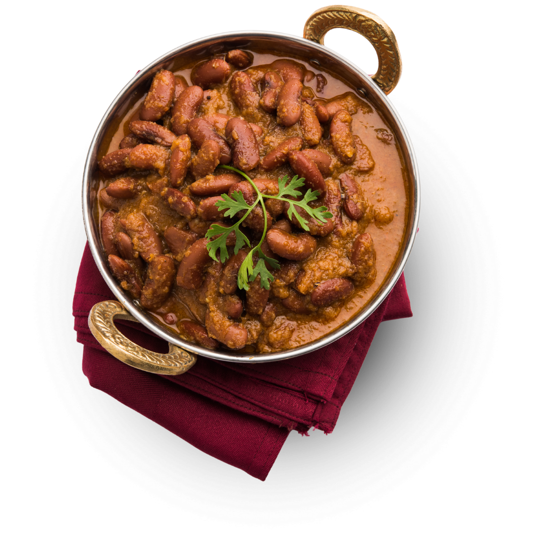 North Indian-style rajma curry with kidney beans in a rich tomato gravy, garnished with coriander and served in a brass bowl.