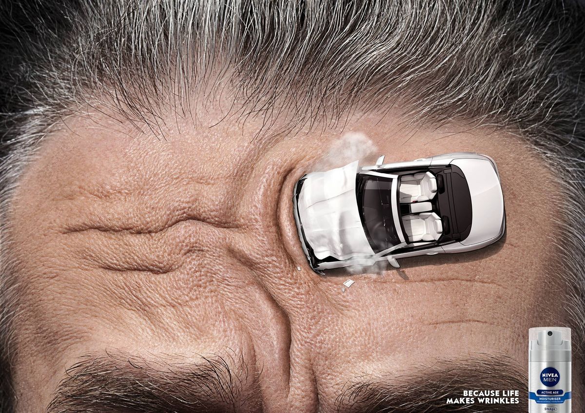NIVEA Men print ad showing a miniature crashed car beside forehead lines and a moisturizer bottle