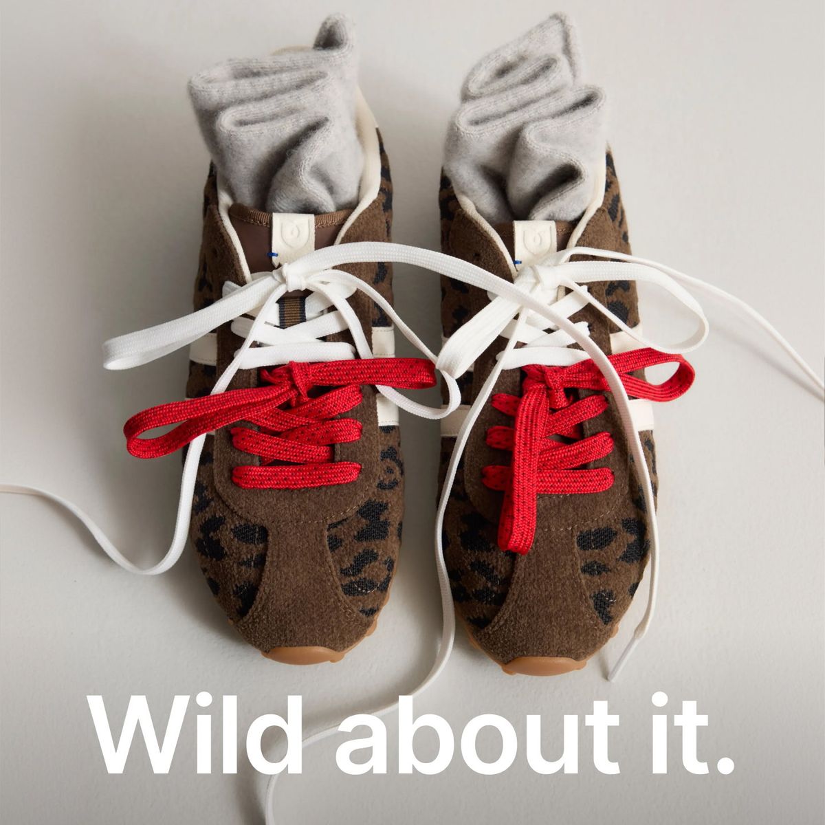 Rothy's leopard-print sneakers with red and white laces, rolled gray socks and the headline Wild about it.