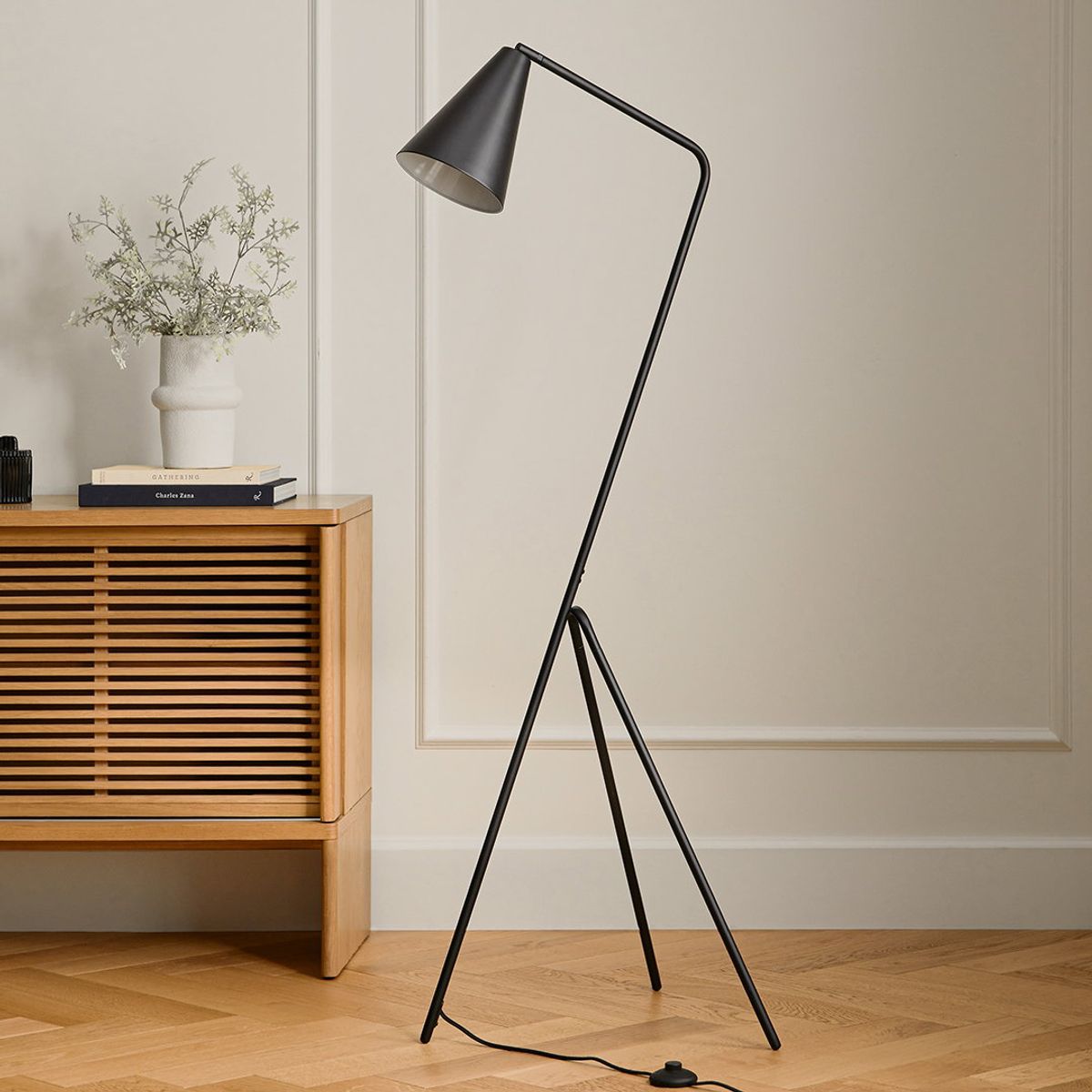 Article floor lamp ad showing the lamp beside a wood cabinet in a furnished room