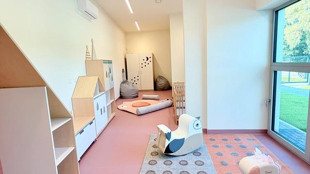 Sala Małych Kroków — jasna sala z meblami w kształcie domków, miękkimi siedziskami i dużym oknem